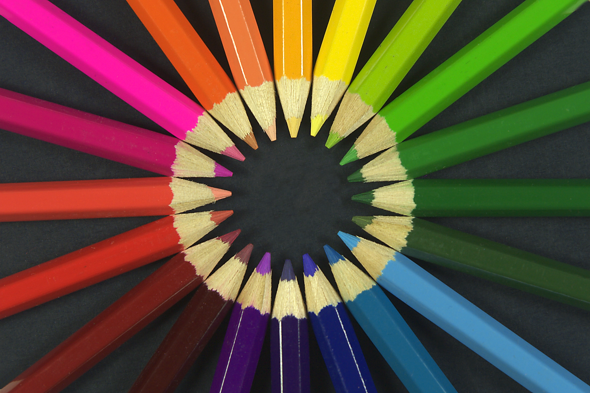 Circle of rainbow coloured coluring pencils
